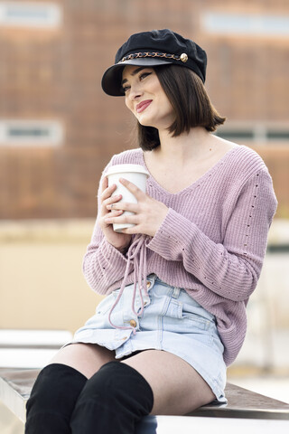 Porträt einer modischen jungen Frau mit Kaffee zum Mitnehmen, lizenzfreies Stockfoto