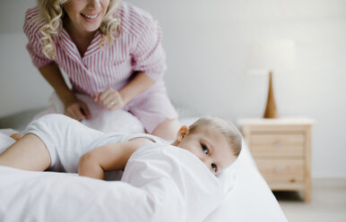 Lächelnde Mutter und Kleinkind Sohn im Bett zu Hause - HAPF02799