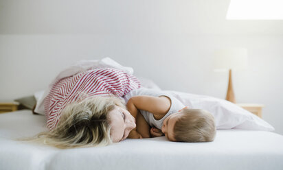 Mother and toddler son lying in bed at home - HAPF02801