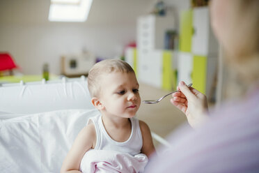 Mother giving medicine to toddler son at home - HAPF02822