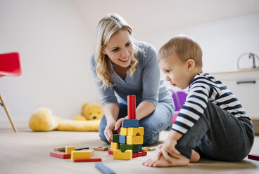 Happy mother and toddler son playing with building blocks at home - HAPF02827