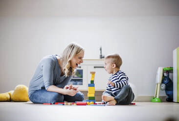 Happy mother and toddler son playing with building blocks at home - HAPF02828