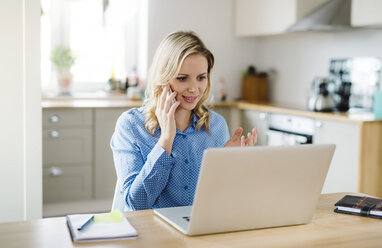 Woman with laptop and cell phone working at home - HAPF02853