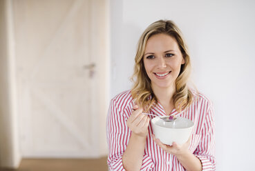 Smiling woman having breakfast in the morning at home - HAPF02866