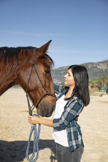 Spain, Tarifa, woman with horse on the beach - KBF00375