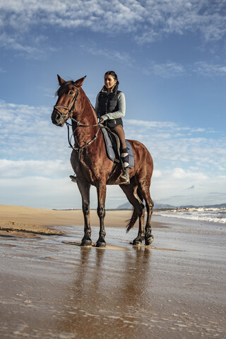 Spanien, Tarifa, Frau auf Pferd am Strand, lizenzfreies Stockfoto