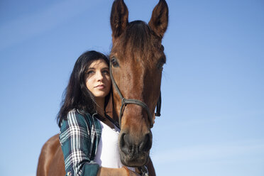 Porträt einer Frau mit Pferd unter blauem Himmel - KBF00379