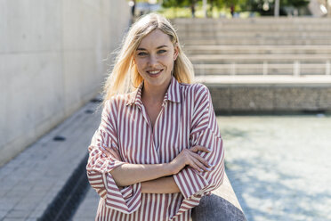 Portrait of smiling blond woman wearing striped shirt - GIOF05456