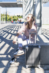 Spanien, Barcelona, junge Frau mit Trolley-Tasche wartet am Bahnhof - GIOF05466