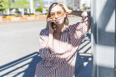 Portrait of blond young woman on the phone outdoors - GIOF05471