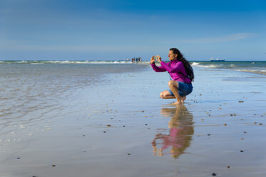 Dänemark, Jütland, Skagen, Grenen, Frau beim Fotografieren von Nord- und Ostsee - UMF00903