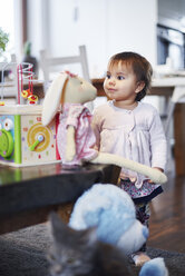Niedliches Babymädchen spielt mit Kuscheltier zu Hause - ABIF01079