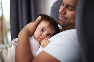 Liebevoller Vater, der seine kleine Tochter zu Hause umarmt - ABIF01108