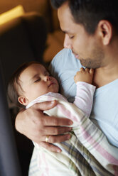Liebevoller Vater betrachtet das schlafende Mädchen in seinen Armen - ABIF01110