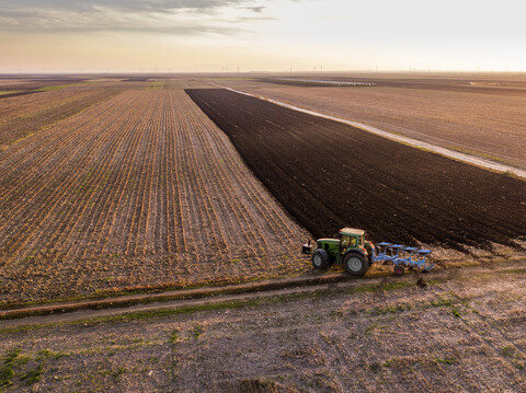 Serbia, Vojvodina. Tractor plowing field in the evening stock photo