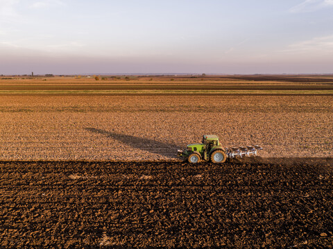 Serbien, Vojvodina: Traktor pflügt Feld am Abend, lizenzfreies Stockfoto