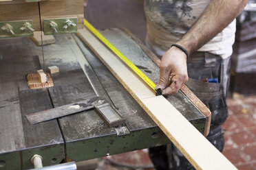 Carpenter measuring a length of wood in Sweden - FOLF09613