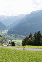 Mädchen geht entlang einer Landstraße in Vorarlberg, Österreich - FOLF09616