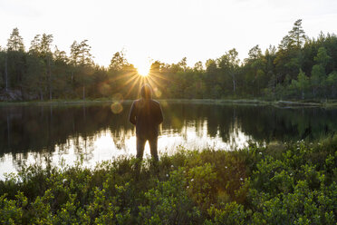 Mann steht am Flussufer in Ostergotland, Schweden - FOLF09625