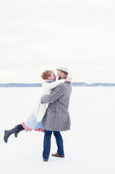 Junger Mann und Frau spielen im Schnee in Schweden - FOLF09644