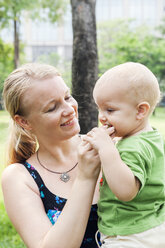 Mother feeding son strawberry - FOLF09678