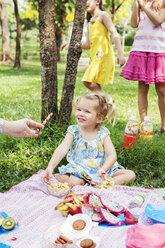 Mutter gibt Tochter Süßigkeiten beim Geburtstagspicknick - FOLF09680