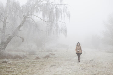 Teenage girl walking through mist in Blekinge, Sweden - FOLF09729