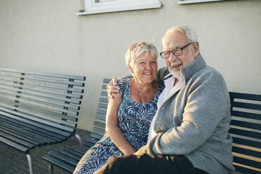 Porträt eines älteren Paares, das sich auf einer Bank umarmt - FOLF09750