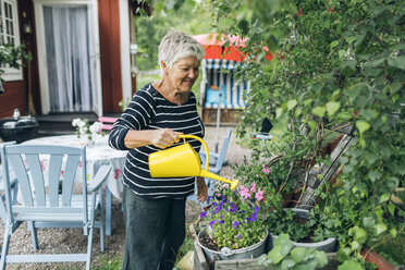 Ältere Frau beim Gießen des Gartens - FOLF09761
