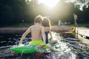 Bruder und Schwester auf einem Poolspielzeug in einem See in Kappemalagol, Schweden - FOLF09762