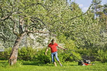 Mid adult man mowing lawn in Heinola, Finland - FOLF09822