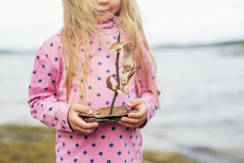 Mädchen hält ein Boot aus Baumrinde in Finnland - FOLF09833