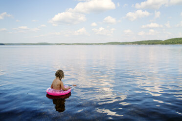 Girl floating in a lake in Finland - FOLF09839