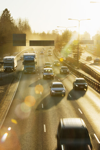 Autos auf der Landstraße bei Sonnenuntergang in Helsinki, Finnland, lizenzfreies Stockfoto