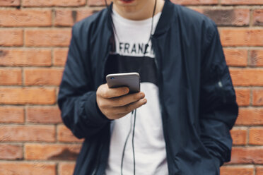 Teenage boy holding a cell phone in Sweden - FOLF09897