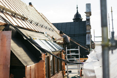 Dachdeckerarbeiten an einem Gebäude in Stockholm, Schweden, lizenzfreies Stockfoto