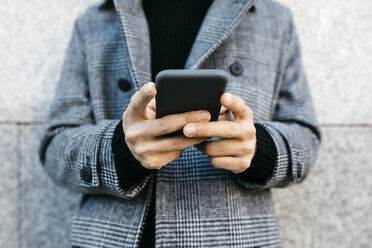 Man's hands holding smartphone, close-up - JRFF02463