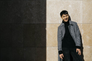 Portrait of fashionable young man wearing black turtleneck pullover and grey coat - JRFF02482