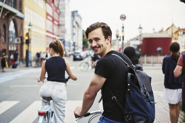 Young man riding a bicycle in Copenhagen, Denmark - FOLF09934