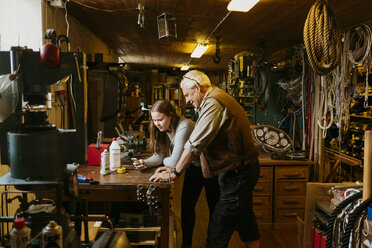 Rope maker and his teenage apprentice looking at cell phone - FOLF09972