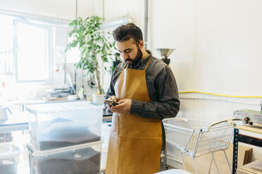 Small business owner in his coffee roaster shop - FOLF09983