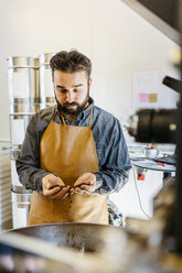 Small business owner working in his coffee roaster shop - FOLF09988