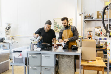 Zwei Männer kochen Kaffee in einer Großküche in Schweden - FOLF10010