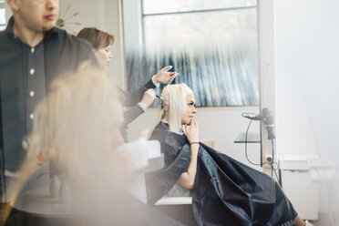 Friseurin beim Färben der Haare ihrer Kunden in Schweden - FOLF10019