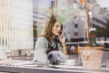 Barista benutzt Smartphone hinter dem Fenster des Cafés - FOLF10035