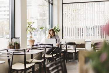 Barista benutzt Smartphone am Laptop im Café - FOLF10039