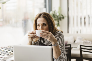 Barista trinkt Kaffee am Laptop in einem Cafe - FOLF10040