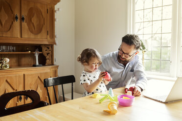 Mid adult man and girl sitting at a dining table in Sweden - FOLF10052