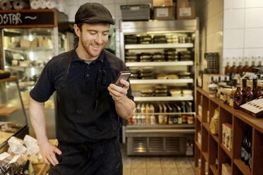 Fishmonger holding smart phone in store - FOLF10063