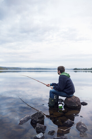 Mittelgroßer Mann beim Angeln an einem See in Dalarna, Schweden, lizenzfreies Stockfoto